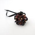 Chainmail Halloween ornament in black and orange with purple accents, handmade dodecahedron ball