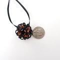 Chainmail Halloween ornament in black and orange with purple accents, handmade dodecahedron ball