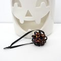 Chainmail Halloween ornament in black and orange with purple accents, handmade dodecahedron ball