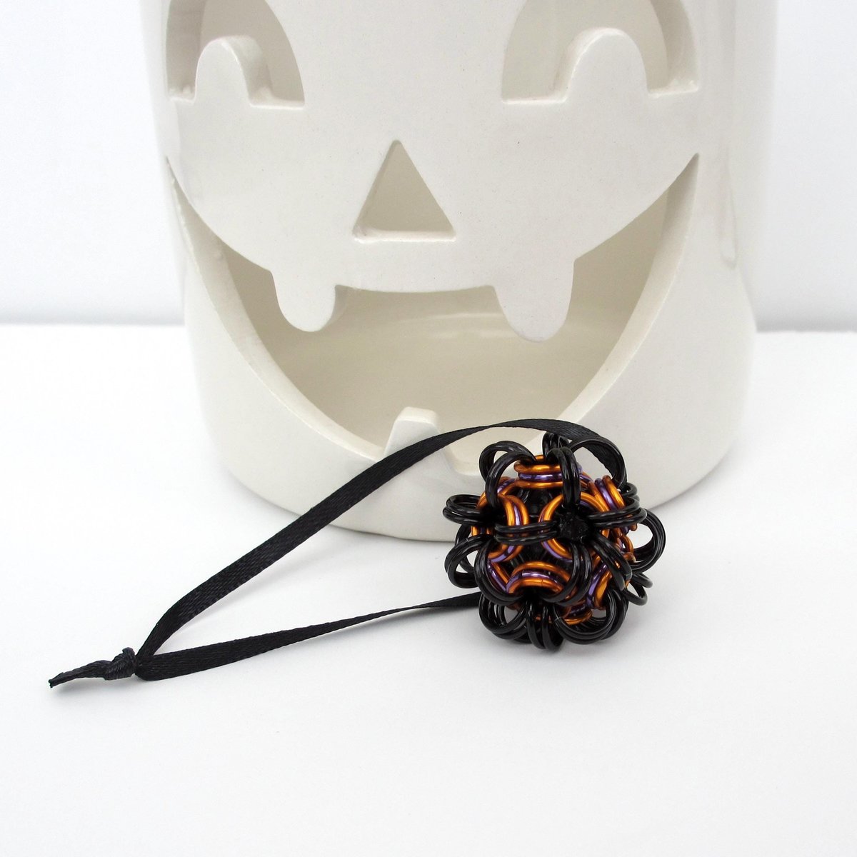 Chainmail Halloween ornament in black and orange with purple accents, handmade dodecahedron ball